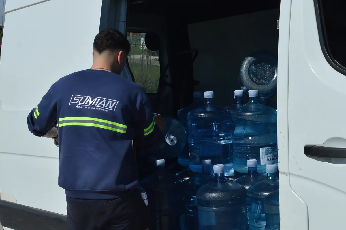 Repartidor de Sumian bajando bidones de 20 litros del cami&oacute;n
